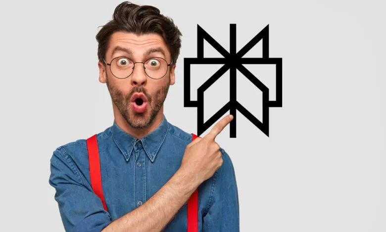 Surprised man in glasses points to a black geometric symbol on a light gray background.