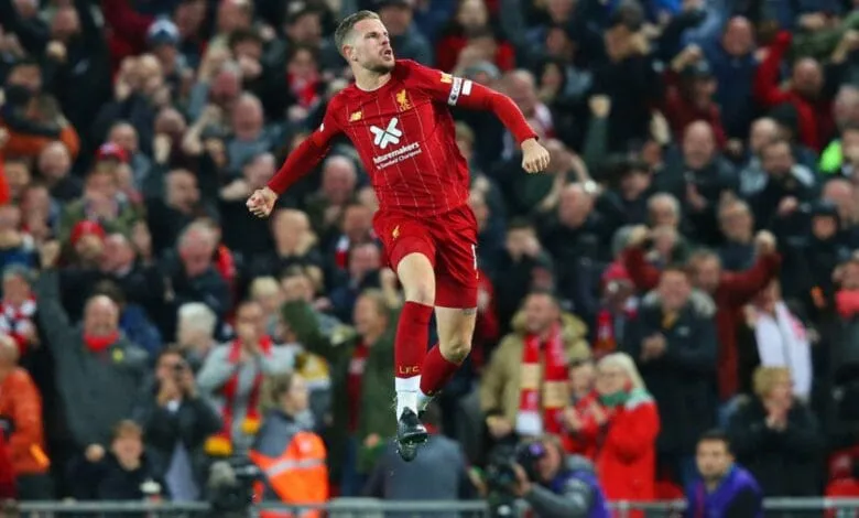 Liverpool's Trent Alexander-Arnold celebrates a goal, leaping in the air amidst a cheering crowd.