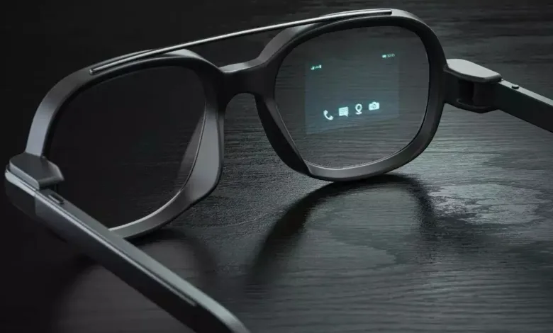 Close-up of sleek black smart glasses displaying phone, message, location, and camera icons on a dark surface.