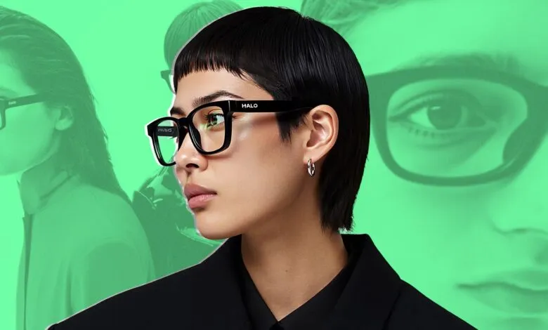 Stylish person wearing black Halo glasses against a green background. Modern eyewear fashion.