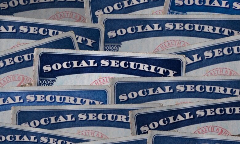 Close-up of numerous Social Security cards overlapping, showing the blue and white design and text.