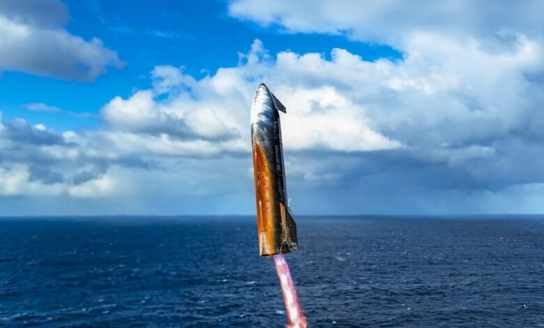 SpaceX Starship rocket launch over ocean, fiery exhaust trail visible against a partly cloudy sky.