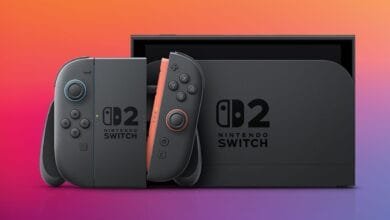 Nintendo Switch OLED model with gray and coral Joy-Cons, shown in its dock.
