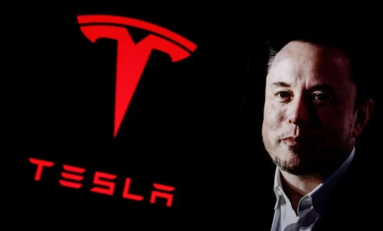 Elon Musk, CEO of Tesla, is shown in profile against a backdrop of the illuminated Tesla logo.