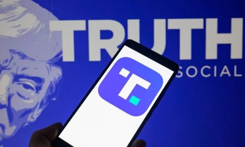 Close-up of a smartphone displaying the Truth Social app logo against a blurred background featuring Donald Trump and the Truth Social branding.