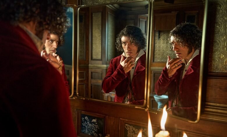 A man in a red velvet jacket admires himself in a tri-fold mirror, adjusting his collar. Candlelight illuminates the scene.