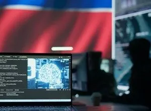 Laptop displaying brain-shaped code on screen, with blurred figures working in a cybersecurity command center in the background.
