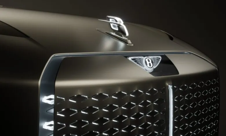 Close-up of a Bentley's illuminated grille and hood ornament, showcasing intricate details and a luxurious design.