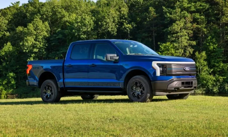 Blue Ford F-150 Lightning STX electric truck in a field.