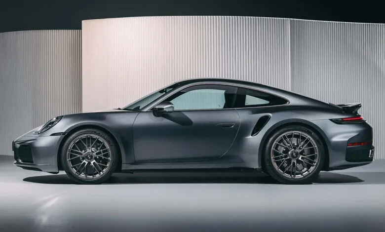 Sleek, dark gray Porsche 911 Turbo S Hybrid shown in profile against a modern, minimalist backdrop.