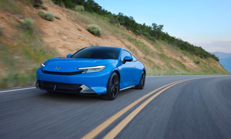 Vibrant blue Honda Prelude speeding along a winding mountain road.