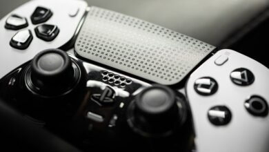 Close-up of a PlayStation DualSense Edge controller, showcasing its unique back panel with etched symbols and sleek black and white design.
