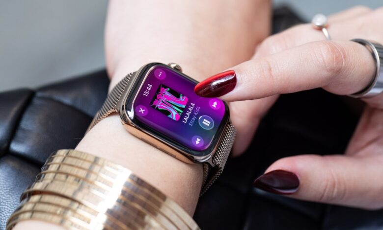 Close-up of a woman's wrist wearing a gold Apple Watch playing Stray Kids' Lalala song.