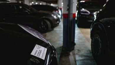 Close-up of a Porsche AG research and development sticker on a black car in a dimly lit parking garage.
