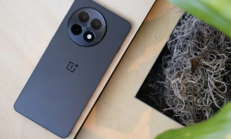Close-up of a dark gray OnePlus 13R smartphone with a circular camera module.