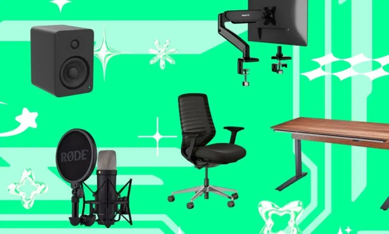 Home office setup with ergonomic chair, standing desk, monitor arm, microphone, and speakers.