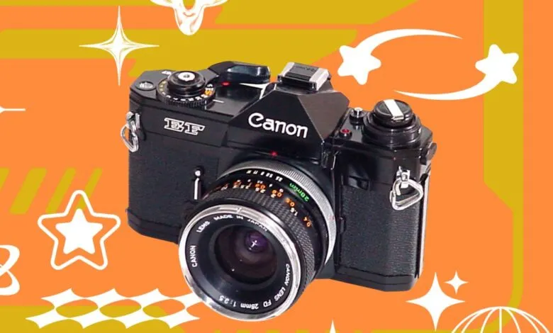 Black Canon AE-1 Program film camera with a 28mm lens on a vibrant orange and gold background.