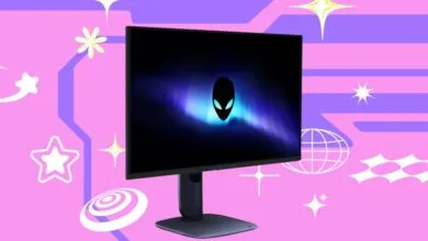 Alienware gaming monitor on pink background with abstract shapes.