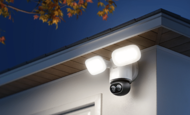 Reolink dual-lens security camera with integrated floodlights mounted on a house exterior at night.