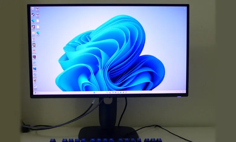 Windows 11 desktop on an Alienware monitor, showing the default blue wallpaper and some open applications.