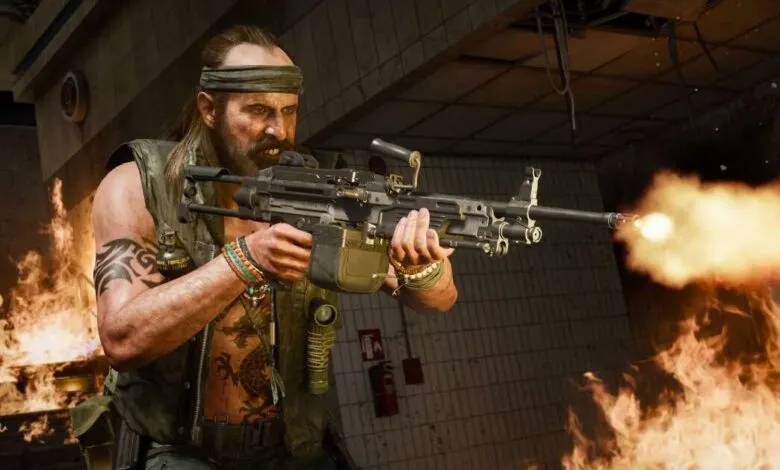 Call of Duty character firing a machine gun amidst flames.