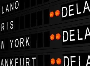 Close-up of a departure board showing flight destinations and times.