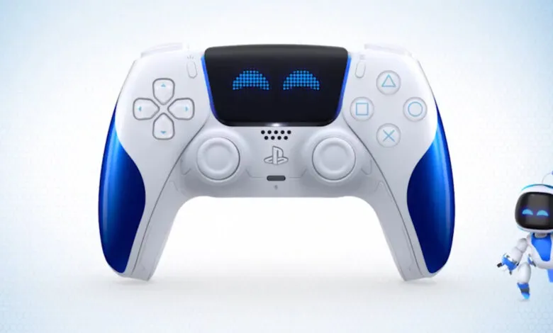 White and blue PlayStation 5 DualSense controller with a small robot beside it.