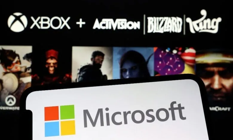 Microsoft logo on a phone screen with Xbox, Activision Blizzard, and King logos in the background.