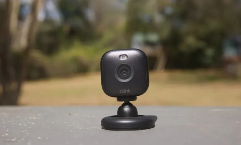 Close-up of a black Blink security camera with a wide lens and LED light.
