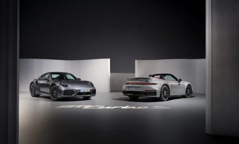 Gray Porsche 911 Turbo S Coupe and Cabriolet showcased in a modern studio setting.