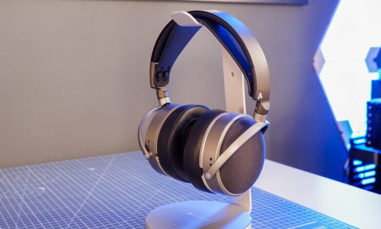 High-end silver and black headphones resting on a stand, showcasing sleek design and premium audio quality.