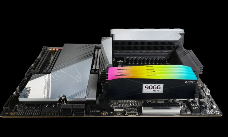 Close-up of a computer motherboard with vibrant RAM sticks installed. The board features a sleek, dark design with silver accents.