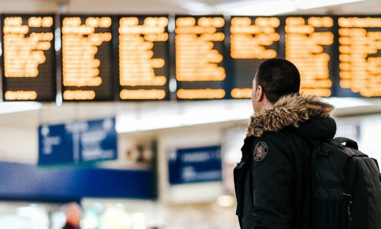 Man in winter coat checks airport departure board.