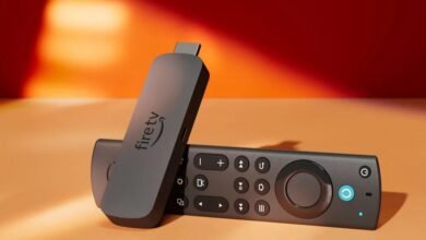 Amazon Fire TV Stick 4K Max and remote control on an orange surface.