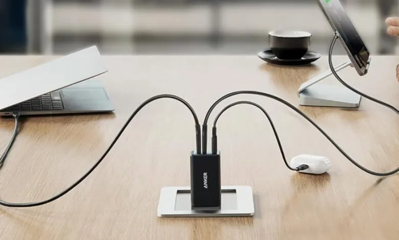 Anker Nano II charger powering a laptop, tablet, and earbuds simultaneously.