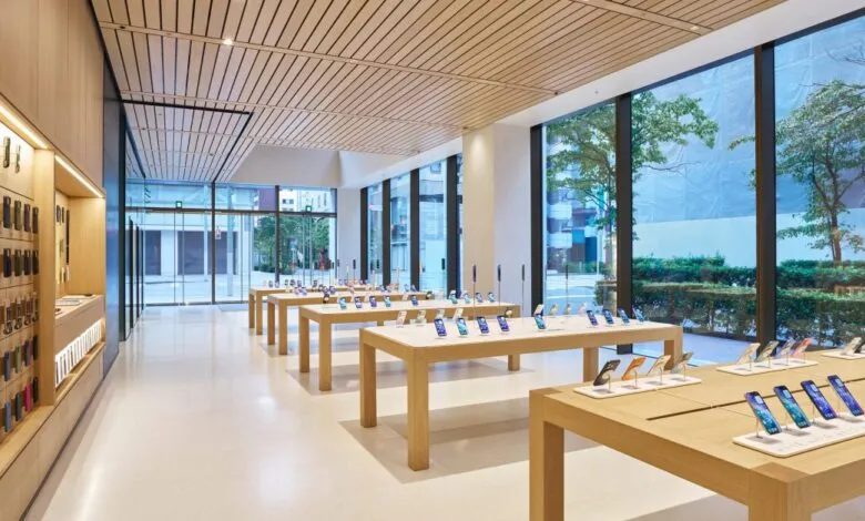 Interior of a modern Apple Store with display tables showcasing iPhones and accessories.