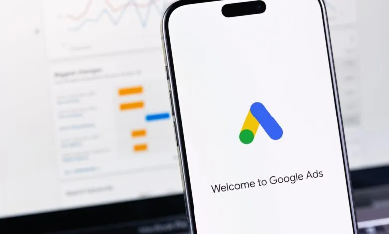 Google Ads app on smartphone, showing welcome screen with logo. Charts are blurred in background.