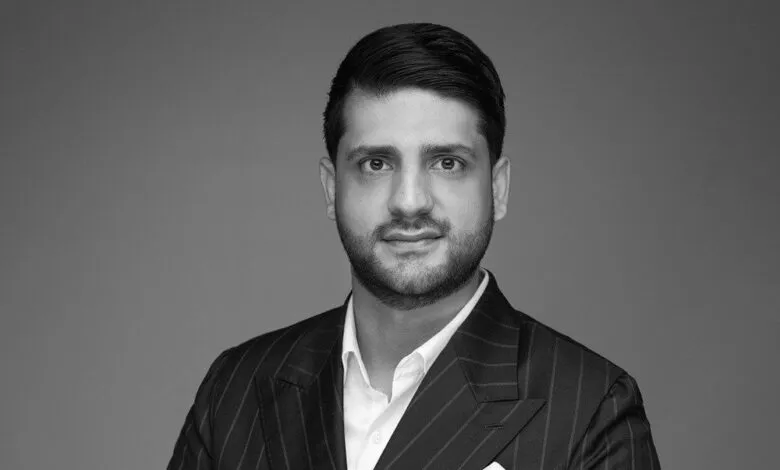 Black and white headshot of Aziz Moti, CEO of ISAB Bullion, wearing a pinstripe suit.