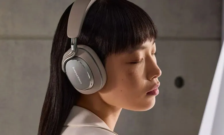 Person wearing beige Bowers & Wilkins PX8 S2 noise-canceling headphones.