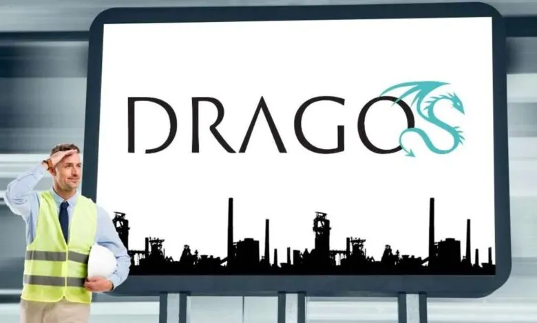 Man in safety vest salutes in front of a large screen displaying the DRAGOS logo and industrial skyline.