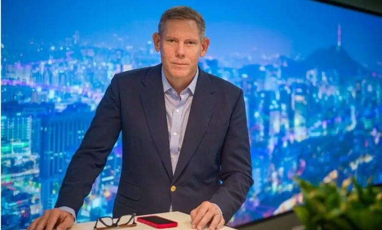 Caspar Herzberg, CEO of AVEVA, stands before a cityscape backdrop.