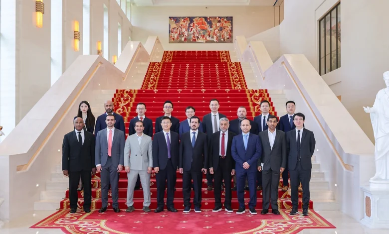 Diverse group of business professionals posing on a grand, red-carpeted staircase.