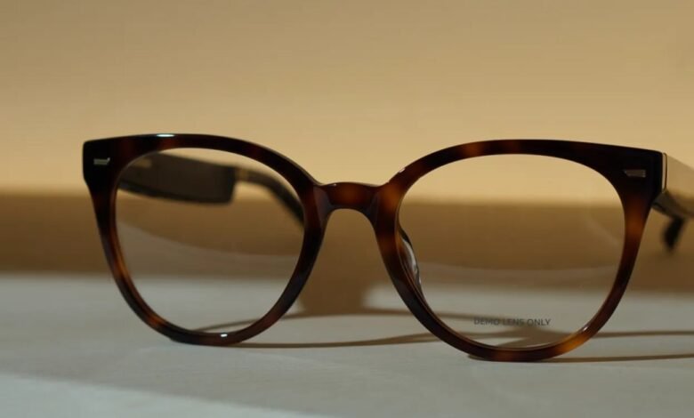 Brown tortoiseshell eyeglasses with clear demo lenses rest on a light surface.