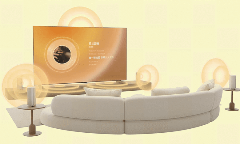 Dolby Atmos Flex Connect wireless speakers surround a curved sofa and TV, creating immersive home theater sound.