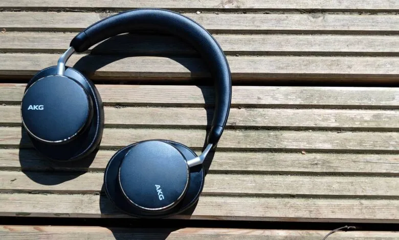 AKG headphones rest on a weathered wooden surface, showcasing their sleek black design and silver accents.