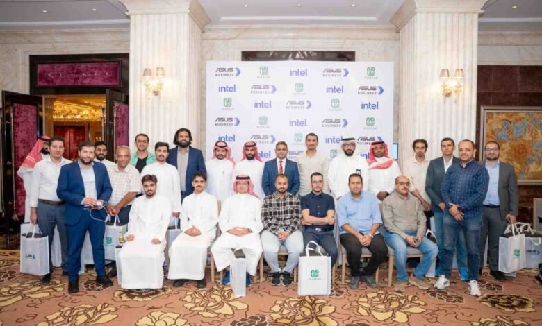 Group of men in business attire and traditional thobes posing for a photo.