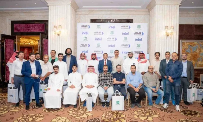 Group of men in business attire and traditional thobes posing for a photo.
