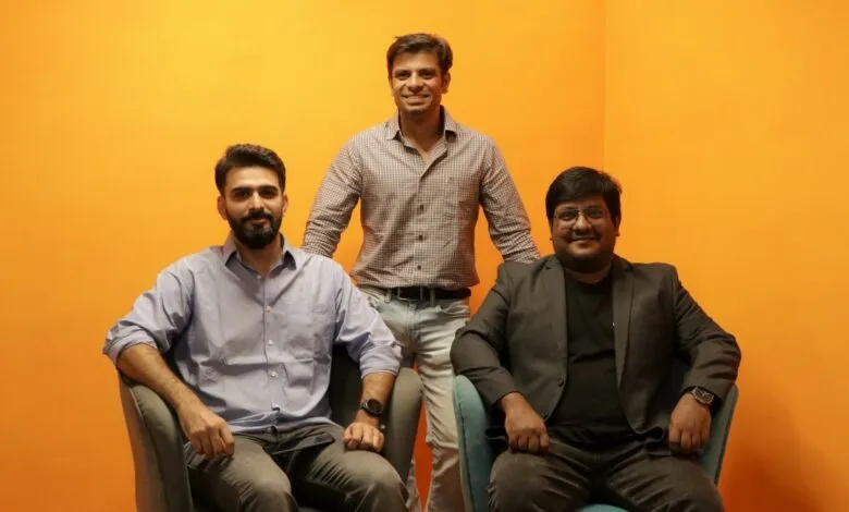 Three founders, Angad Kikla, Rahul Gill, and Naisheel Verdhan, pose against a vibrant orange background.