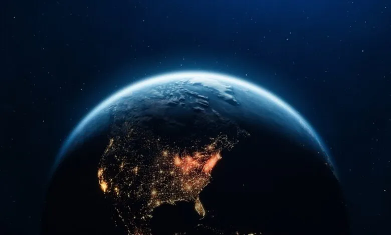 Night view of Earth from space, showing North America's city lights against a dark background.