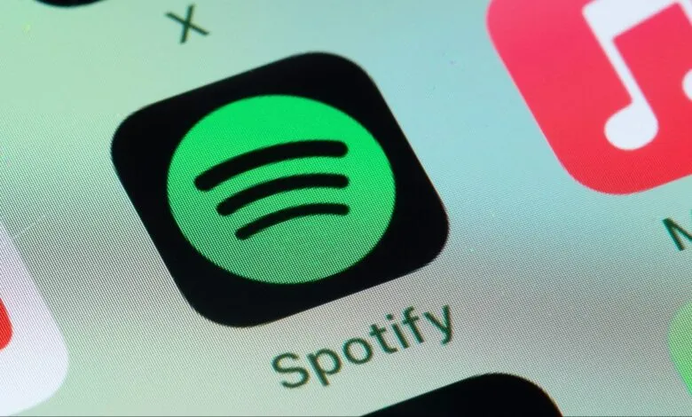 Close-up of the Spotify app icon on a smartphone screen. The icon is green and black.
